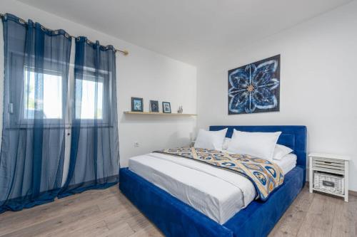 a bedroom with a blue bed and a window at Kuća za odmor Dora in Benkovac