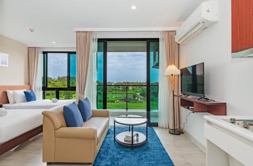 a hotel room with a king bed and a couch at Wyndham Phuket Airport in Nai Yang Beach