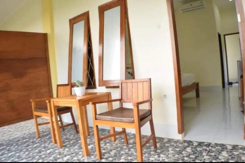 スンギギにあるKJ Inn Homestay Senggigiのテーブル、椅子、鏡が備わるお部屋