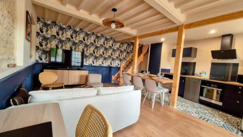 un salon avec un canapé blanc et une table dans l'établissement L'Arromanchaise - Gold Beach, à Arromanches-les-Bains