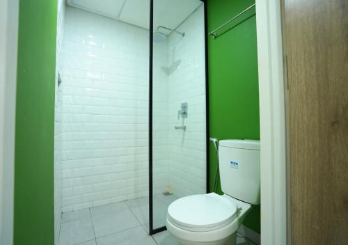a bathroom with a toilet and a glass shower at OFO Kost Premium Syariah Kampung Inggris Pare in Pare