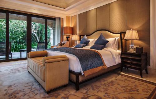 a bedroom with a large bed and a couch at Wanda Reign Resort & Villas Sanya Haitang Bay in Sanya