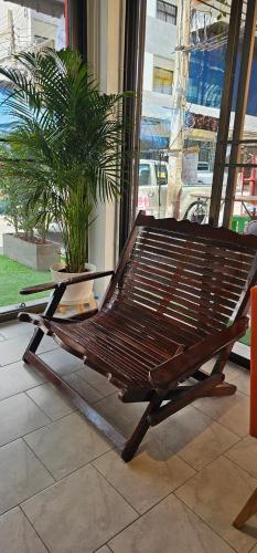 a wooden bench sitting in front of a window at Before We Go Hostel Donmueang in Ban Ko