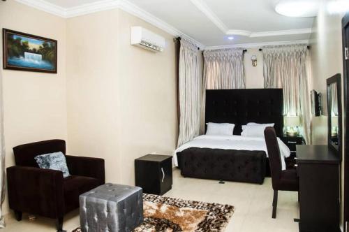 a bedroom with a bed and a desk and a chair at BTT Homes in Lekki