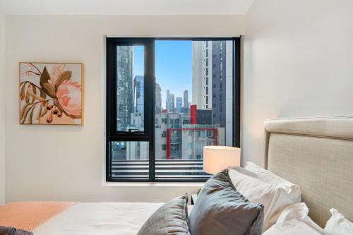 a bedroom with a window with a view of a city at Stay in Luxury at Stature - Sleeps 5 in Melbourne
