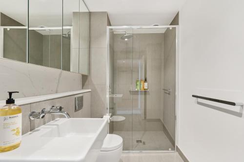 a bathroom with a sink and a toilet and a shower at Stay in Luxury at Stature - Sleeps 5 in Melbourne
