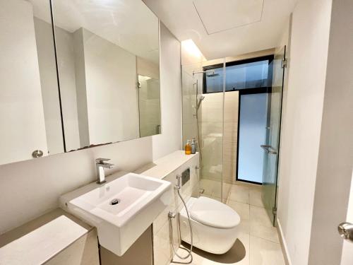 Baño blanco con lavabo y aseo en LB Cozy Home 1-10Pax 3Room Tropicana 4QBeds BalconyTV en Petaling Jaya