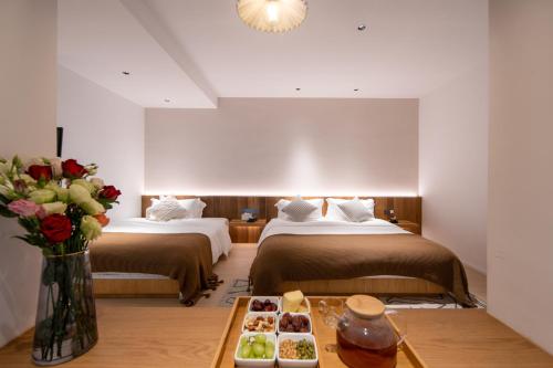 a hotel room with two beds and a tray of food at Hidden Travel Shenzhen Dapeng in Dapeng