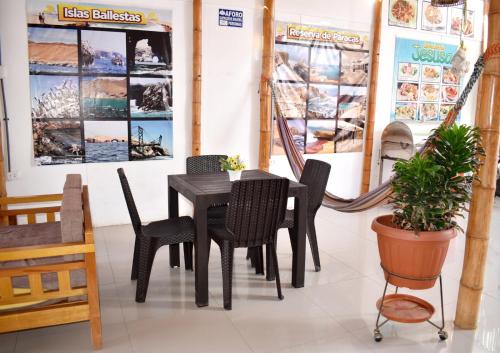 een eetkamer met een zwarte tafel en stoelen bij Hospedaje El Buen Samaritano in Paracas