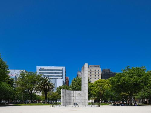 a monument in a park with a city in the background at Vessel Inn Hakata Nakasu in Fukuoka