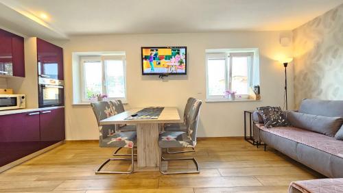 uma sala de estar com uma mesa e cadeiras e um sofá em New Istriaexperience em Koper