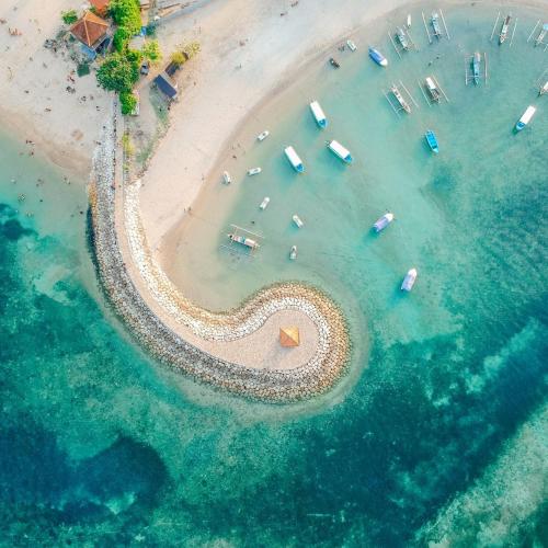 an aerial view of a beach with boats in the water at Tiny Homes, Sanur in Denpasar