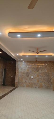 a room with a ceiling fan and a stone wall at Hotel ananya fairview in Khātu