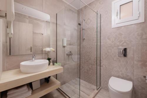 W łazience znajduje się umywalka i przeszklony prysznic. w obiekcie Corfu Town Luxury Studio -B - New w Korfu
