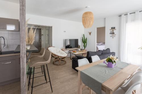 a kitchen and living room with a table and a couch at Appartement T2 proche centre ville in Istres