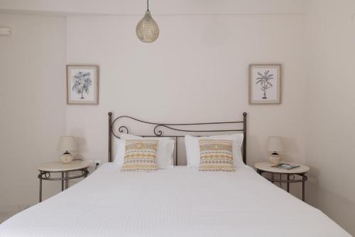 a bedroom with a large white bed with two tables at Corfu Town Luxury Studio -B - New in Corfu