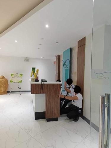two people sitting at a counter in a room at Antara Residence Studio Condo in Talisay