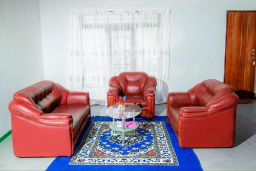 a living room with two red chairs and a glass table at Sun City Family Inn in Hatton