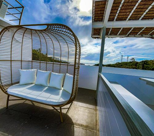 een rotan stoel met 2 kussens op een balkon bij The Pacific Coast in Boracay