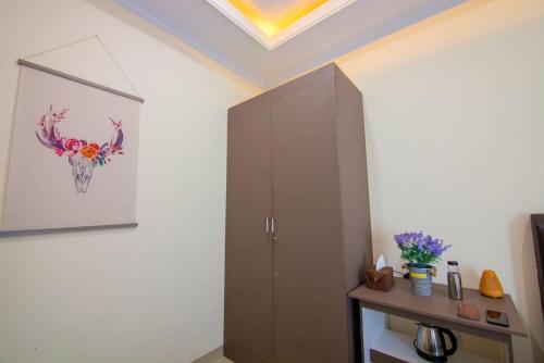 une chambre avec une armoire et un tableau au plafond dans l'établissement RedDoorz syariah near Universitas Islam Riau, à Pekanbaru