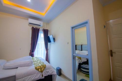 - une petite chambre avec un lit et un miroir dans l'établissement RedDoorz syariah near Universitas Islam Riau, à Pekanbaru