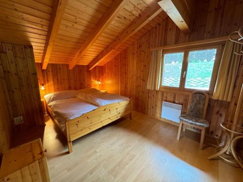 a bedroom with a bed and a chair in a room at Chalet Siesta OG in Bellwald