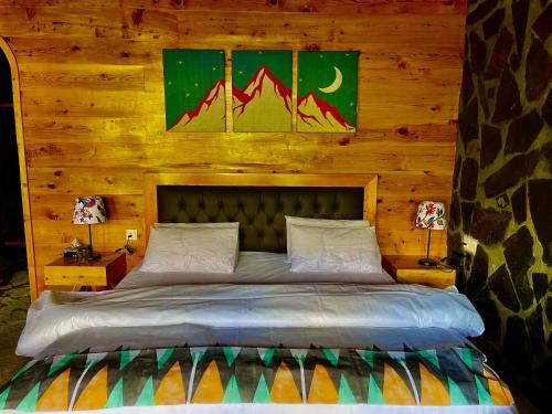 a bedroom with a bed in a wooden cabin at Ridge Inn in Kalām