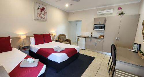 a hotel room with two beds and a kitchen at Charters Towers Motel in Charters Towers