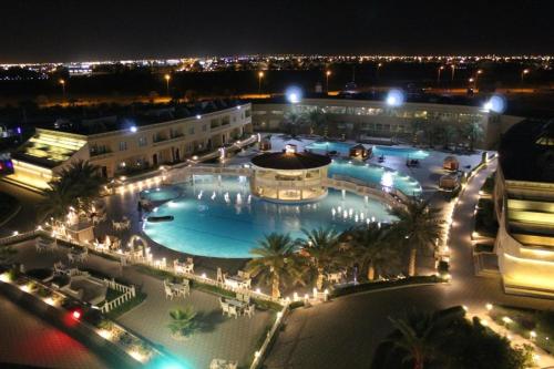a large pool in a building at night at Al Salam Grand Hotel & Resort in Al Buraymī