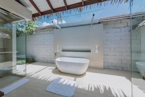 La salle de bains est pourvue d'une baignoire, d'un lavabo et d'une douche. dans l'établissement BuBu Villa, aux Îles Perhentian