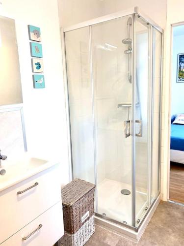 une douche avec une porte vitrée dans une salle de bain dans l'établissement Les goélands au cœur de la Baule, à La Baule
