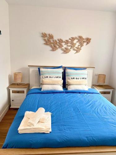 - un lit bleu avec 2 serviettes dans l'établissement Les goélands au cœur de la Baule, à La Baule