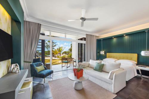 uma sala de estar com um sofá e uma mesa em Long Beach Mauritius em Belle Mare