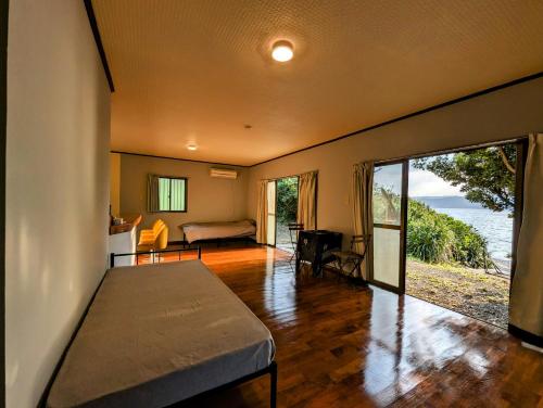 a bedroom with a bed and a view of the ocean at くじらの家 in Amami