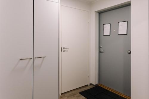 a hallway with white cabinets and a door at Forenom Serviced Apartments Lahti Hennala in Lahti