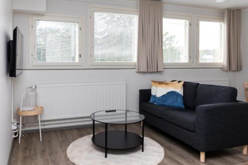 a living room with a couch and a table at Forenom Serviced Apartments Lahti Hennala in Lahti