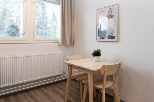 a table and chairs in a room with a window at Forenom Serviced Apartments Lahti Hennala in Lahti