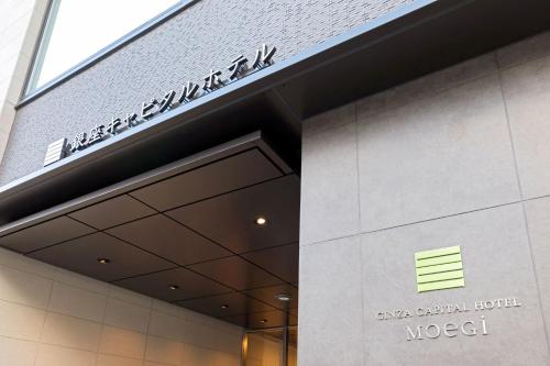 um sinal na frente de um edifício moderno em Ginza Capital Hotel Moegi em Tóquio