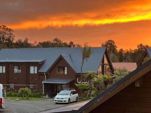 a white car parked in front of a house at Fox Glacier Lodge in Fox Glacier