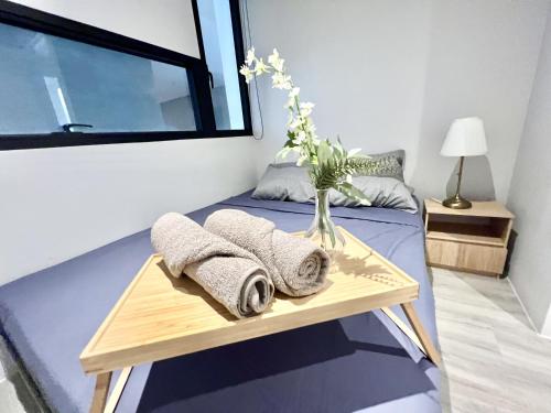 a bedroom with a bed with a vase of flowers on it at LC 1-10Pax 3Room Cozy Home 4Qbed WiFi TV Tropicana in Petaling Jaya