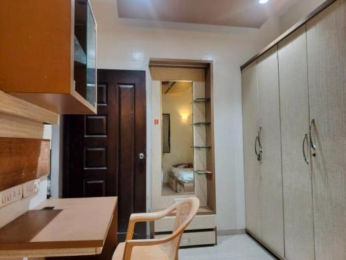 a kitchen with a table and a chair in a room at Luxurious 2BHK villa with garden in Solapur