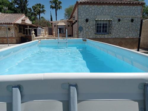 una gran piscina de agua azul frente a una casa en RURAL EL SANTISCAL, en Arcos de la Frontera