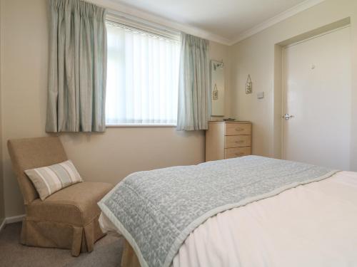 une chambre avec un lit, une chaise et une fenêtre dans l'établissement Bre An Mor, à Germoe