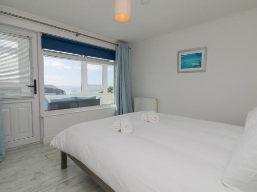 Porthtowan的住宿－St Ives View，白色的卧室设有床和窗户