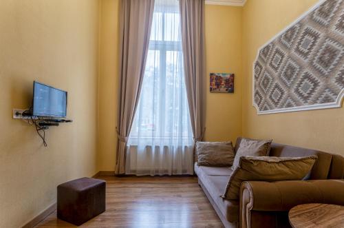 a living room with a couch and a large window at Hotel Middleton in Tbilisi City
