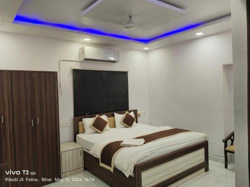 Hotel Destiny في باتنا: غرفة نوم مع سرير مع ضوء أزرق على السقف