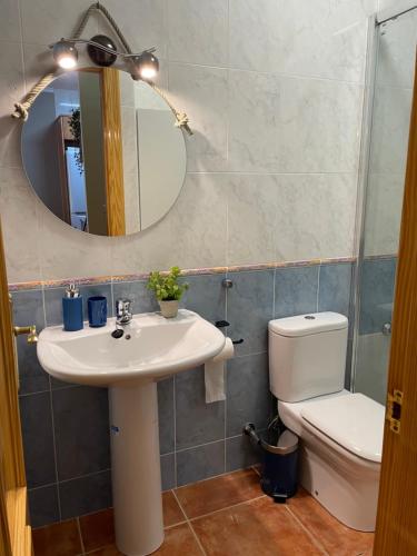 La salle de bains est pourvue d'un lavabo, de toilettes et d'un miroir. dans l'établissement Apartamento en la playa, à Les Cases d'Alcanar