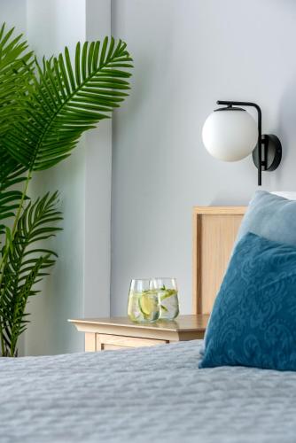 a bedroom with a bed with a blue pillow and a plant at Libyan Princess in Palaiochóra