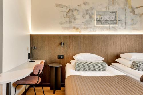 a hotel room with two beds and a desk at Original Sokos Hotel Vaakuna Mikkeli in Mikkeli