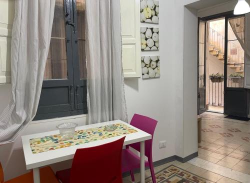 a dining room with a white table and purple chairs at Aria di sale in Trapani
